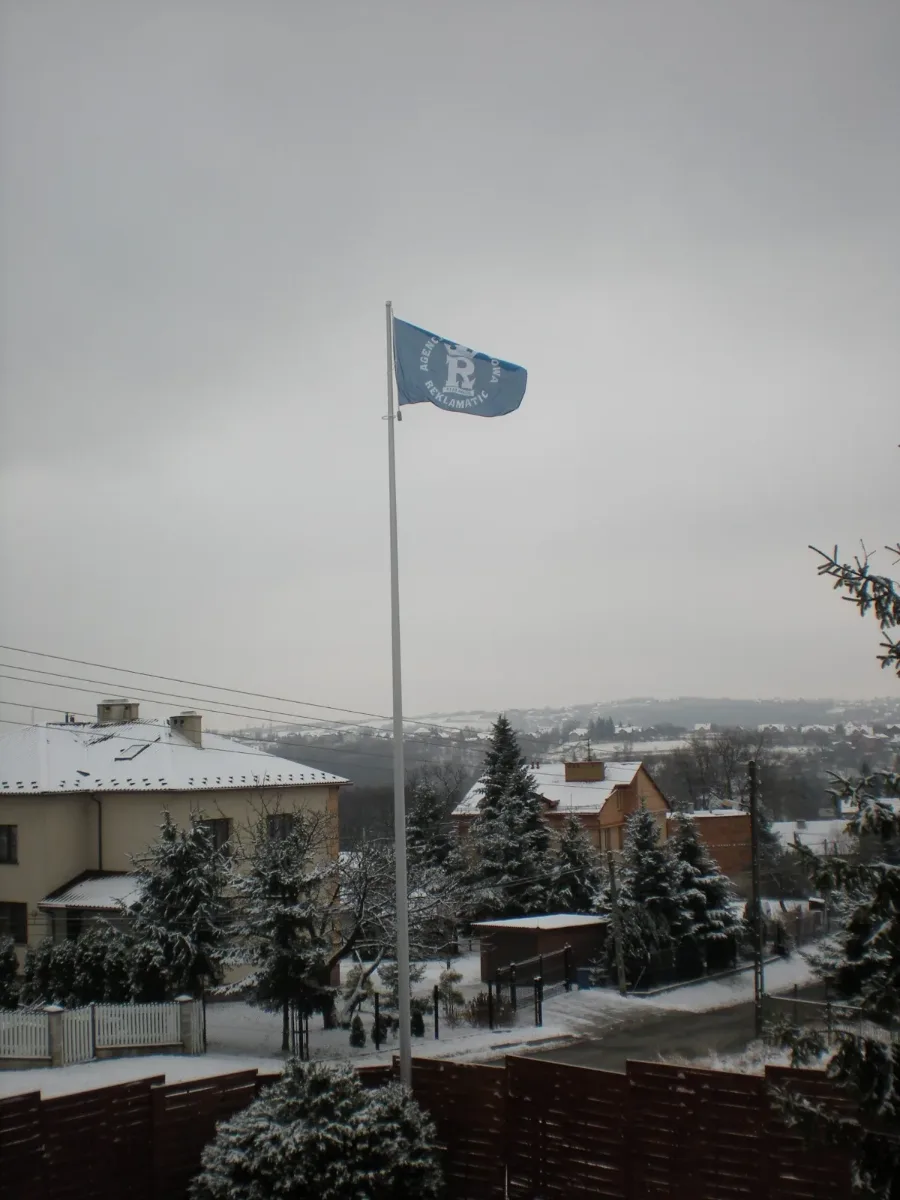 Maszty flagowe aluminiowe zamontowane przed budynkiem firmy