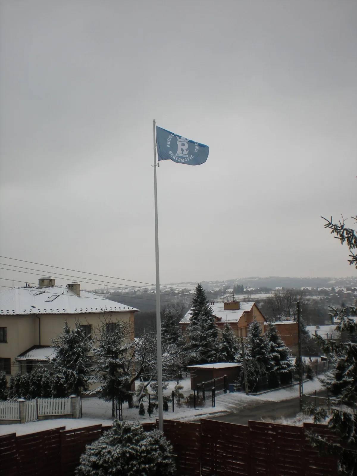 Maszty flagowe aluminiowe zamontowane przed budynkiem firmy